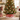 Base per albero di Natale in metallo rosso con decoro villaggio e slitta di Babbo Natale, ambientata in un luminoso soggiorno natalizio