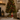 Base per albero di Natale con cervo marrone decorativo, fiocco rosso, pacco regalo verde e supporto portaalbero integrato.