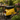 Sgabello Vespa giallo da giardino in stile vintage posizionato su patio tra fiori e piante decorative