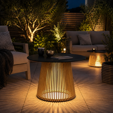 Tavolino da esterno con illuminazione LED integrata in elegante giardino moderno serale con area relax