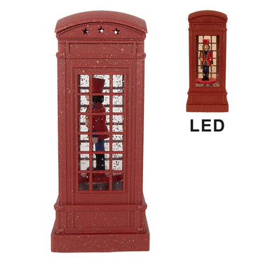 Decorazione natalizia con musica e LED a forma di cabina rossa con soldatino schiaccianoci, fotografata in un elegante ambiente festivo.