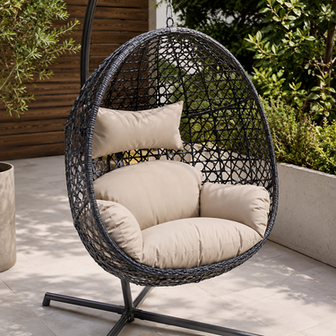 Dettaglio dondolo pensile ovale in rattan nero con morbidi cuscini beige da esterno