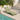 Lettino da piscina verde salvia dal design moderno posizionato a bordo piscina in ambiente outdoor elegante e luminoso