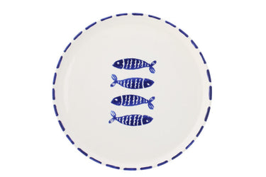 piatto pesci blu ceramica su tavolo legno apparecchiato con insalata e pasta