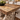 Tavolo in legno con cornice rialzata sul piano e base decorativa intagliata